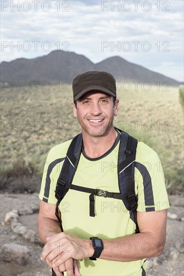 Portrait of smiling Hispanic man hiking in desert