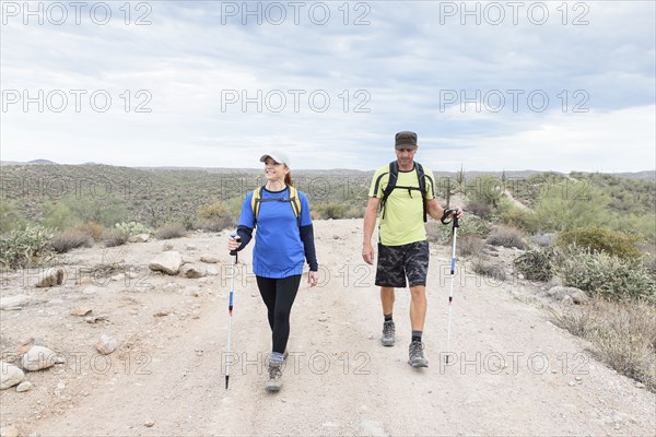 Couple hiking on rocky path in desert