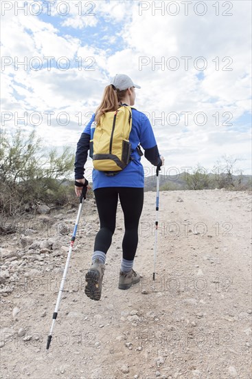Caucasian woman hiking on rocky path in desert