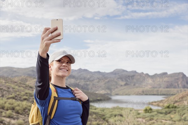Caucasian woman posing for cell phone selfie in desert