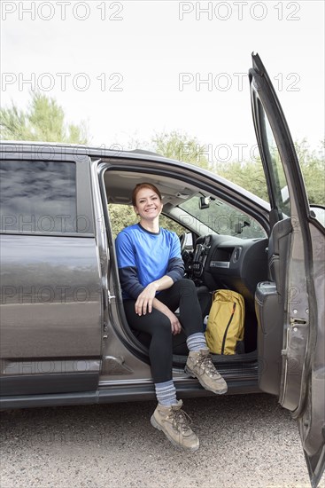 Portrait of Caucasian woman sitting in car with door open