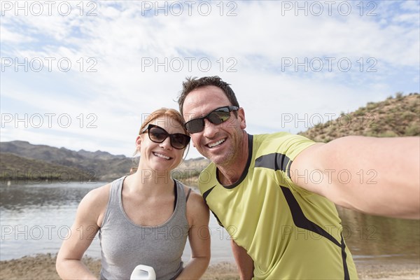 Couple posing for selfie at lake