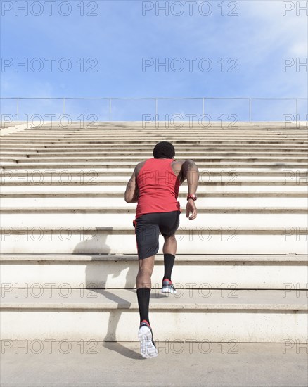 African American man running on bleachers