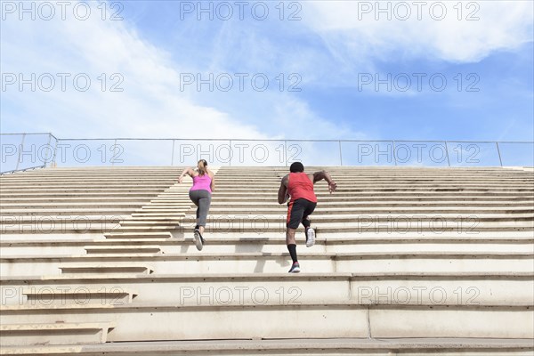 Man and woman running on bleachers