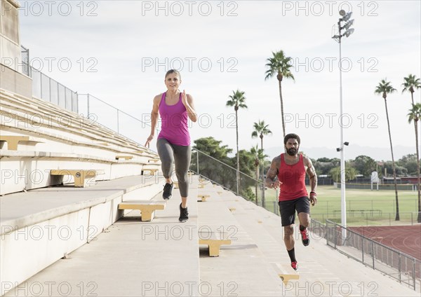 Man and woman running on bleachers