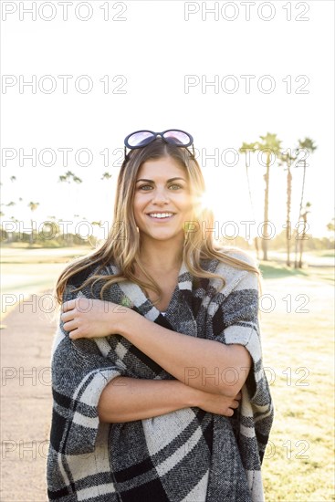 Smiling Hispanic woman wearing plaid poncho