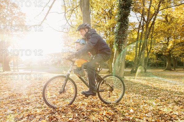 Caucasian father and son riding bicycle