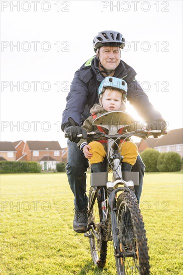 Caucasian father and son riding bicycle