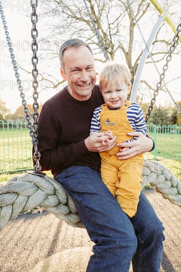 Caucasian father and son playing on swing