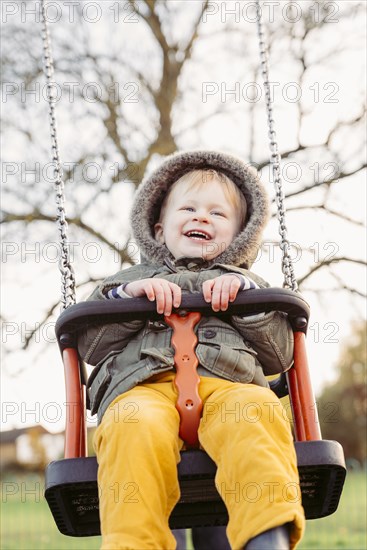 Caucasian boy smiling on swing