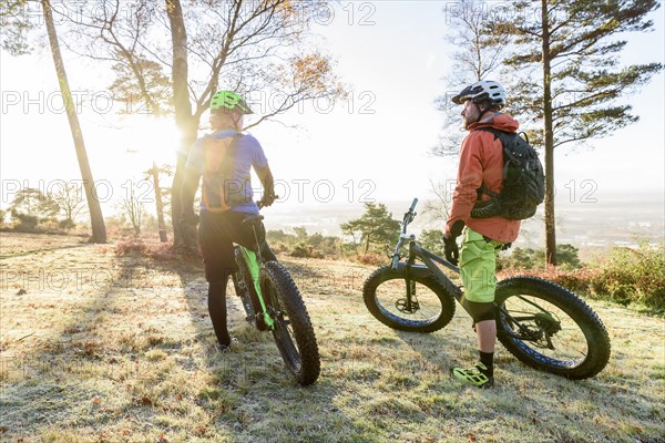 Caucasian couple resting on bicycles