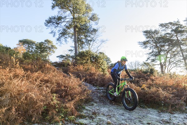 Caucasian woman riding bicycle on hill