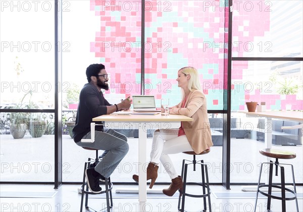 Creative business people talking at table with laptop