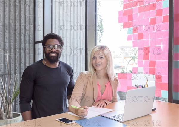 Creative business people posing with laptop at table