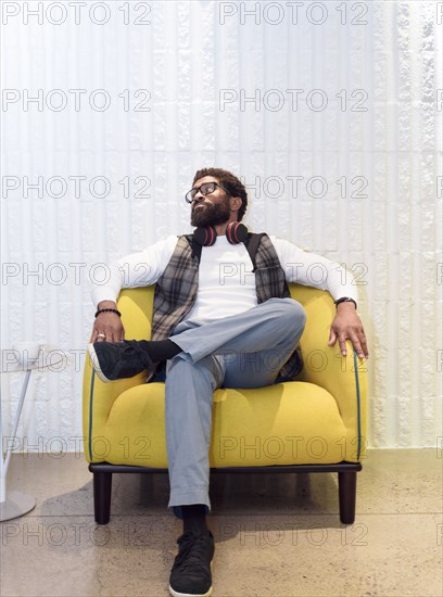 Black man sitting in yellow chair