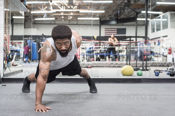 Black man doing push-up in gymnasium