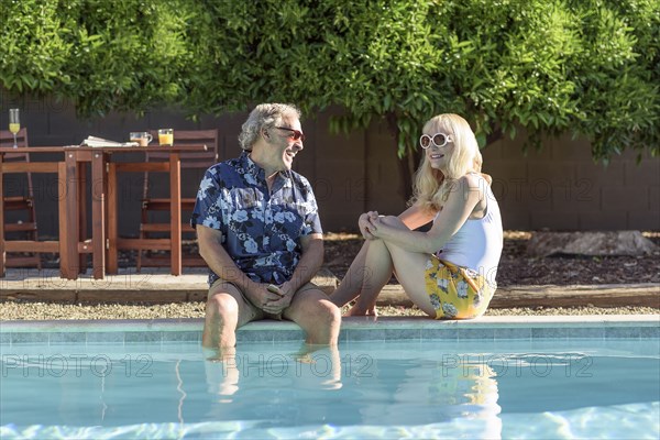 Caucasian couple laughing near swimming pool