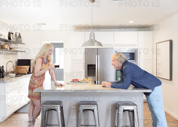 Caucasian couple talking in the kitchen