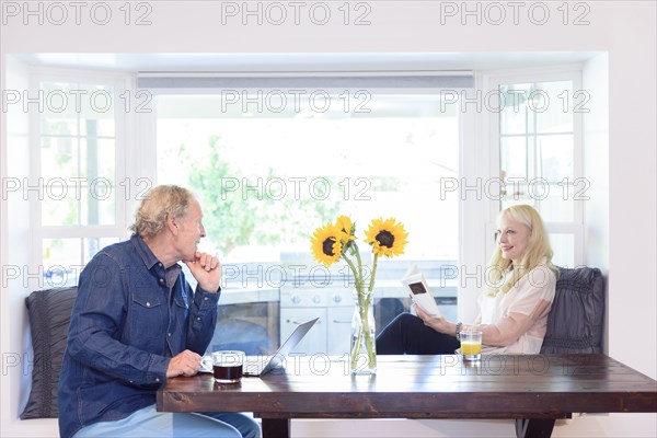 Caucasian couple relaxing near window