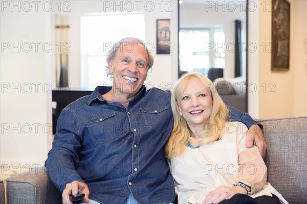 Caucasian couple watching television in livingroom