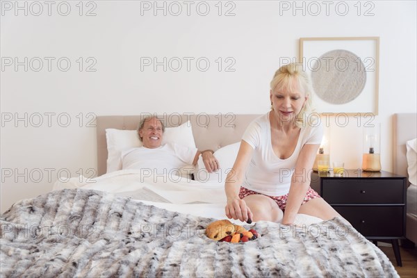 Caucasian woman eating breakfast in bed