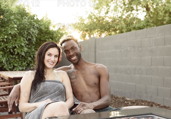 Portrait of smiling couple wrapped in towels near fire pit