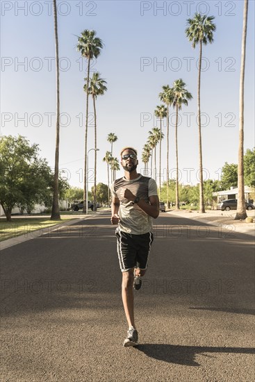 Black man running on street in neighborhood