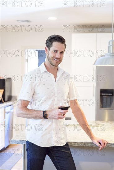 Smiling Caucasian man drinking red wine