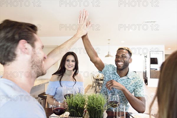 Friends drinking red wine and high-fiving