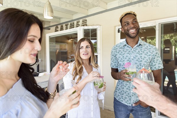 Smiling friends with cold drinks talking outdoors