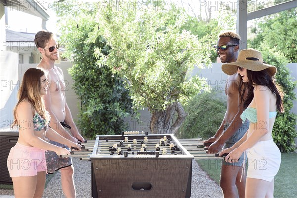 Friends playing foosball outdoors