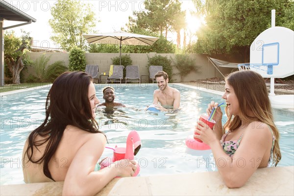 Women watching men playing in swimming pool