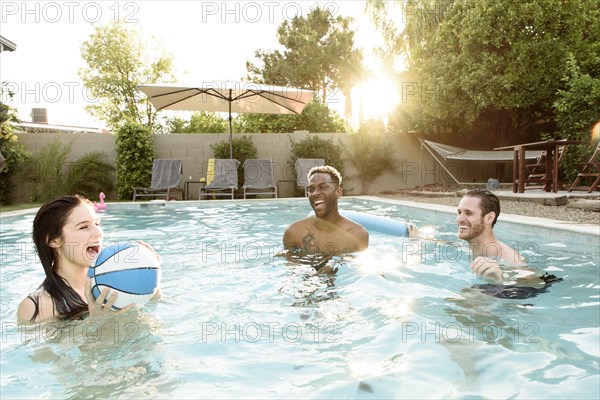Friends playing basketball in swimming pool
