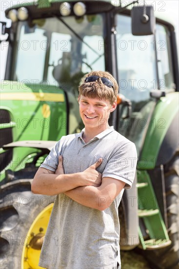 Confident Caucasian man standing near tractor