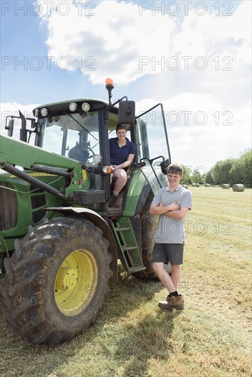 Smiling Caucasian couple posing near tractor