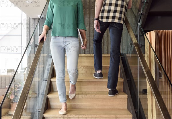 Caucasian man and woman passing on staircase