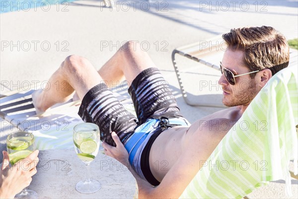 Caucasian couple relaxing poolside