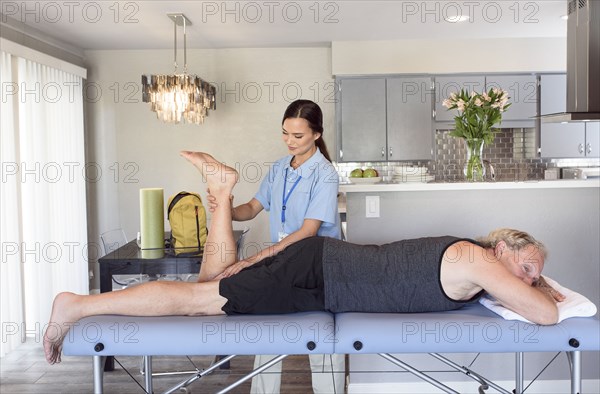 Physical therapist stretching leg of man