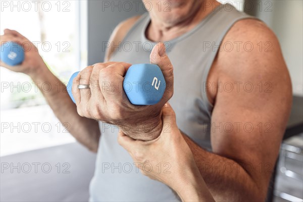 Physical therapist helping man lifting weights