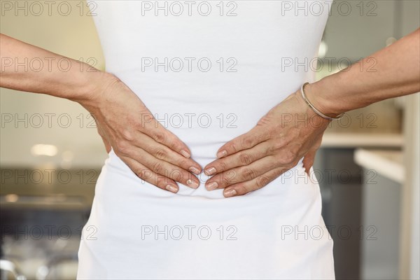 Hands of mixed race woman rubbing lower back