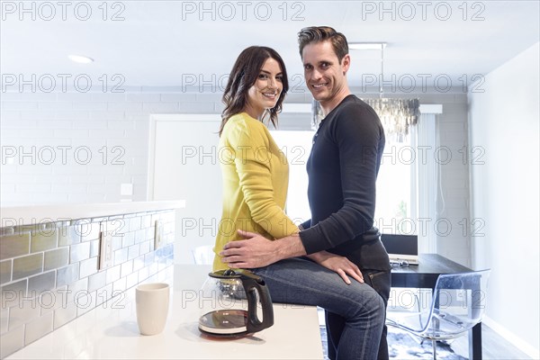 Portrait of Caucasian couple embracing on kitchen counter
