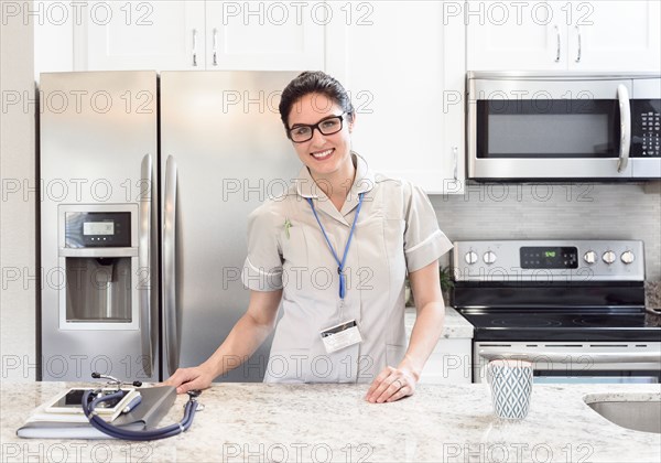 Caucasian nurse posing in kitchen