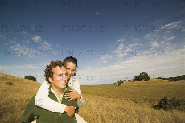 Man giving woman piggy back ride