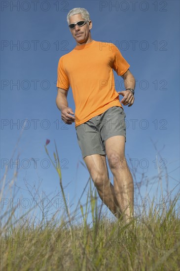 Middle-aged man walking through grass