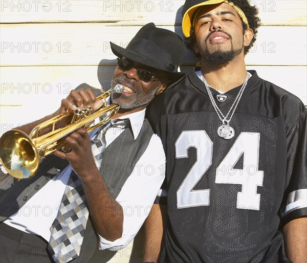 Young African man next to senior African man with trumpet