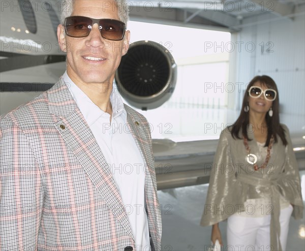 Couple standing in front of airplane in a hanger