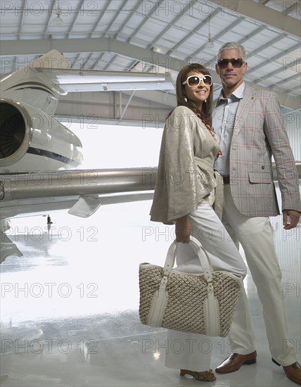 Couple standing in airplane hanger