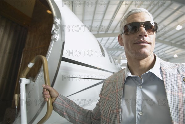 Middle-aged man boarding airplane in hanger