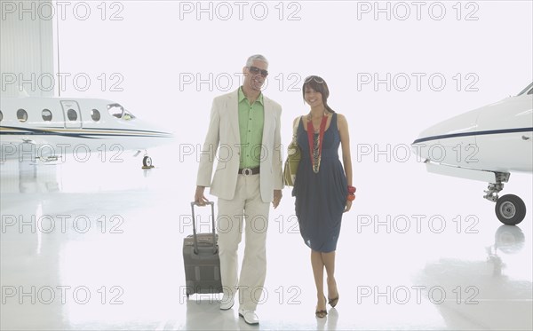 Couple walking in airplane hanger
