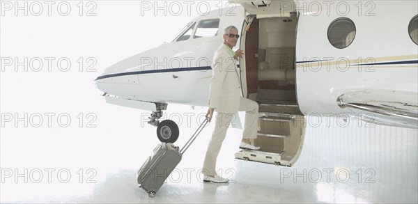 Middle-aged man boarding airplane in hanger
